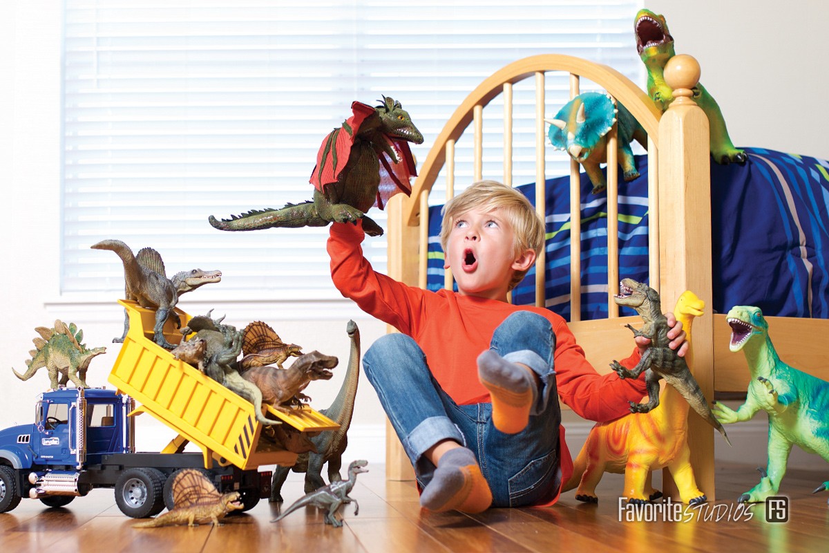 Catalog photographers at Favorite Studios for products with talent. Youth model playing with dinosaur and dump truck product toys.